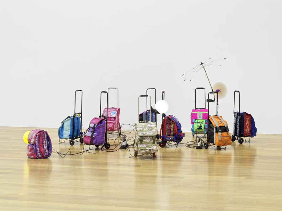 Liliana Moro, Le Nomadi, 2023, [Die Nomadinnen I The Nomads (Isa, Maria, Rosa, Sarah, Gina, VALIE, Paola, Patti, Rita, Pina], 9 Trolleys, 10 Rucksäcke, verschiedene Materialien I 9 trolleys, 10 backpacks, mixed media, Dimensionen variabel I Dimensions variable. Installation view, Kunstmuseum Liechtenstein, Vaduz. Foto I Photo: Stefan Altenburger Photography Zurich. © Liliana Moro