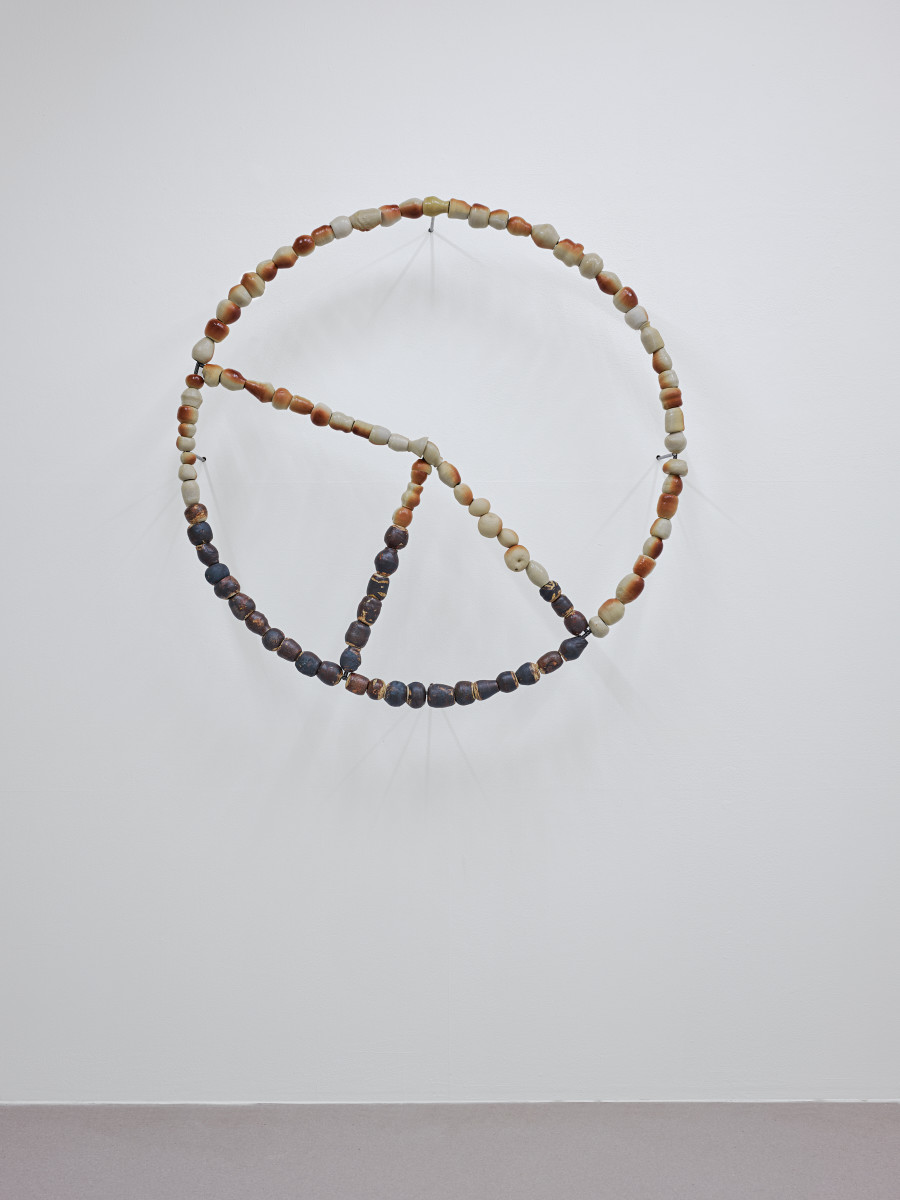 Camille Dumond, Everything but sliced, Ferme de la Chapelle, Geneva, Sept-Oct 2025. Camille Dumond, Some things that used to be edible are lethal now (harvest 3). Sandstone, steel, 100 × 100 cm, 2025. Part of a series of three circles on the wall. Photo credit: ©Nicolas Delaroche Studio